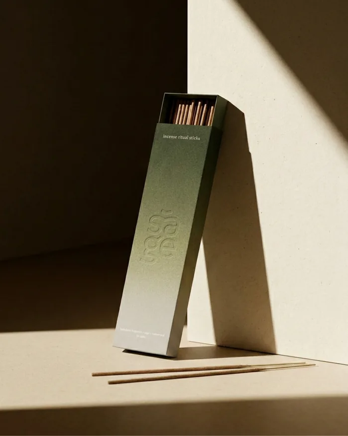 Sage incense ritual sticks — a sage-green box standing against a sunlit wall